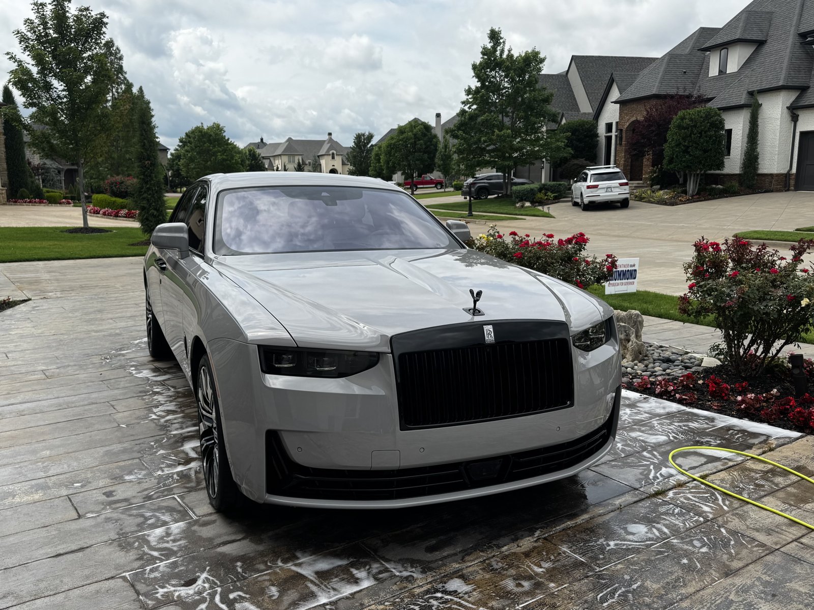 White Rolls-Royce Ghost being hand washed in a driveway