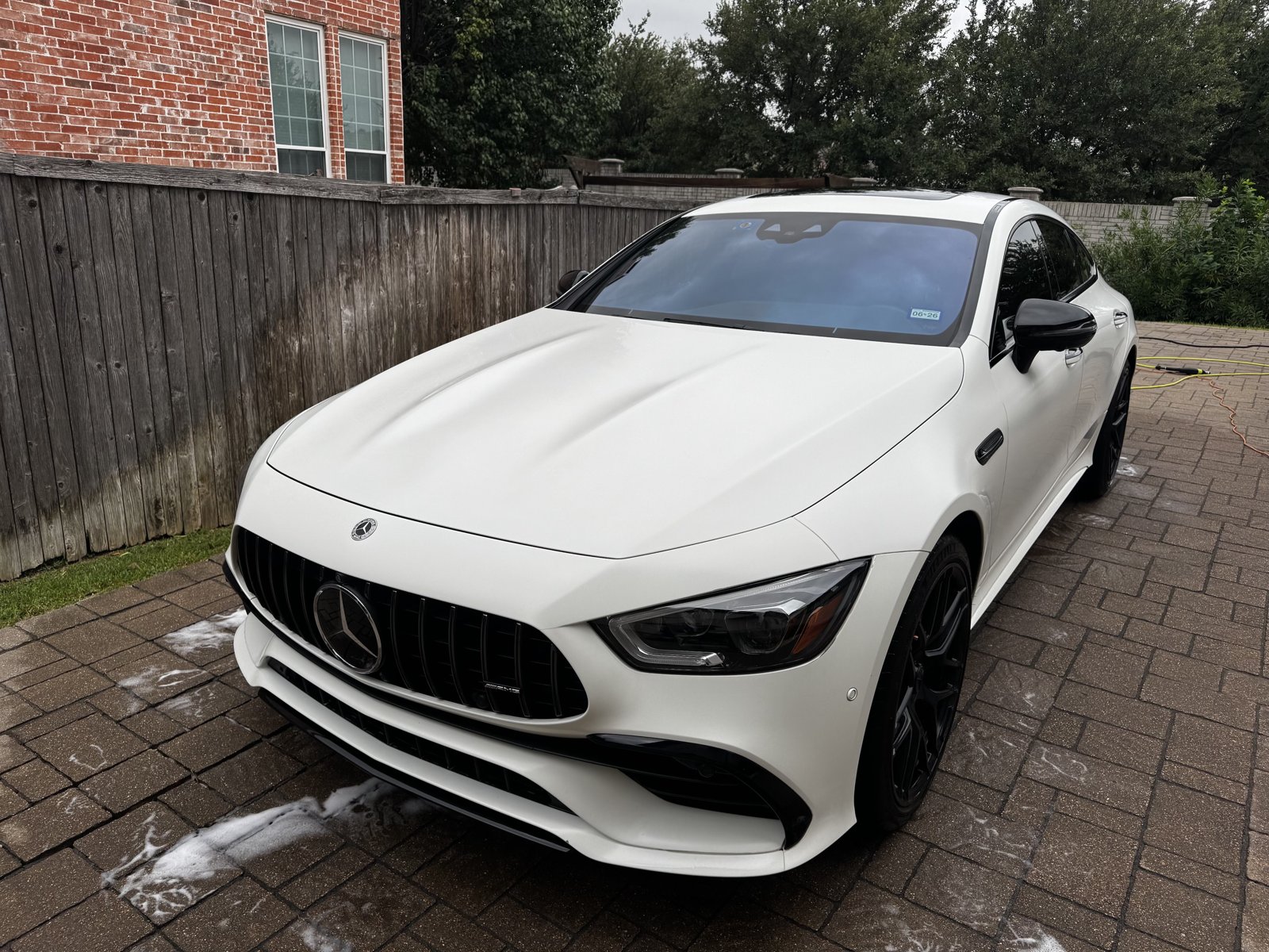 White Mercedes-AMG GT 4-door coupe covered in wash foam